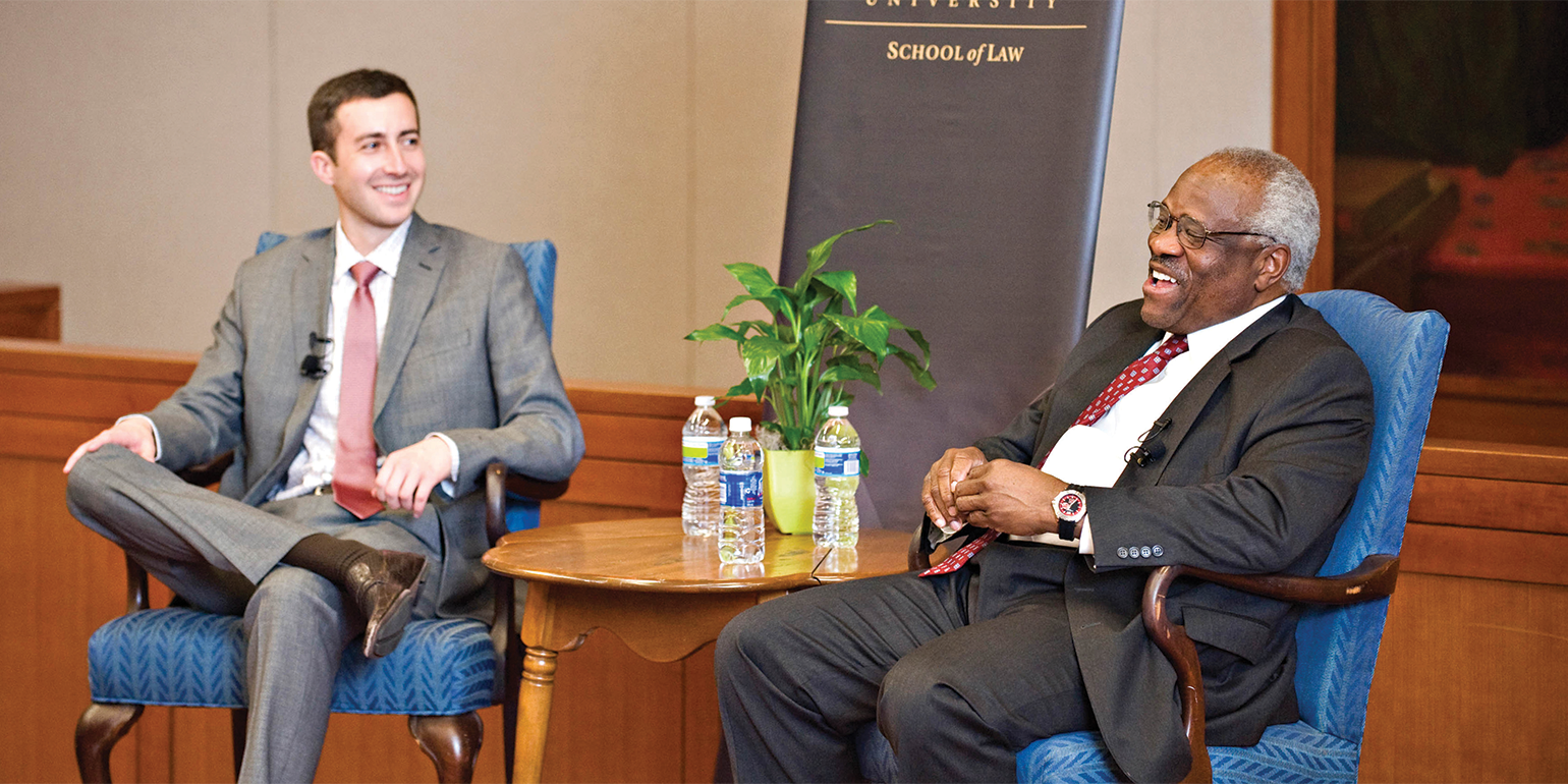 Marc Rigsby (JD ’12), left, and Justice Clarence Thomas, right, during a 2012 “Conversation With” event in the Worrell Professional Center. 